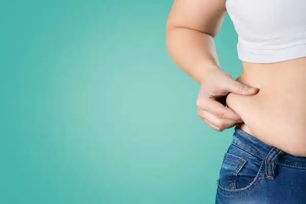 Image of woman pinching her love handles to show weight gain Telford
